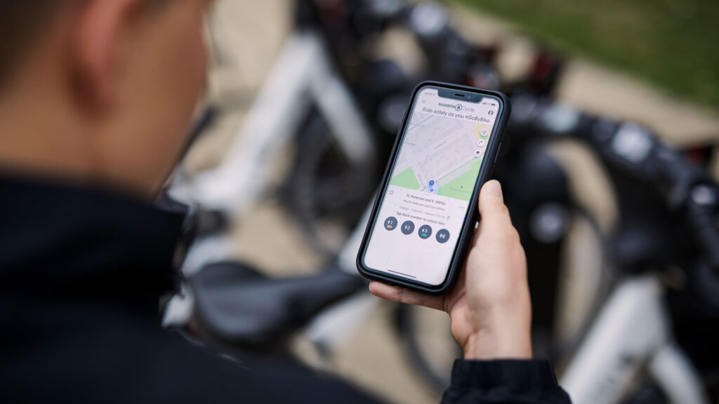 Person looking at smart phone displaying a bike share app, BCycle