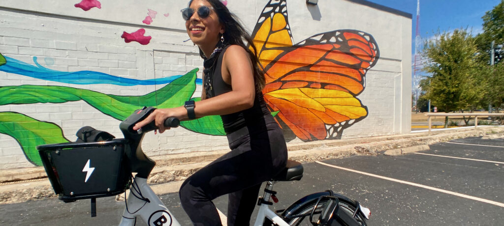 Latina woman riding a bike share bicycle